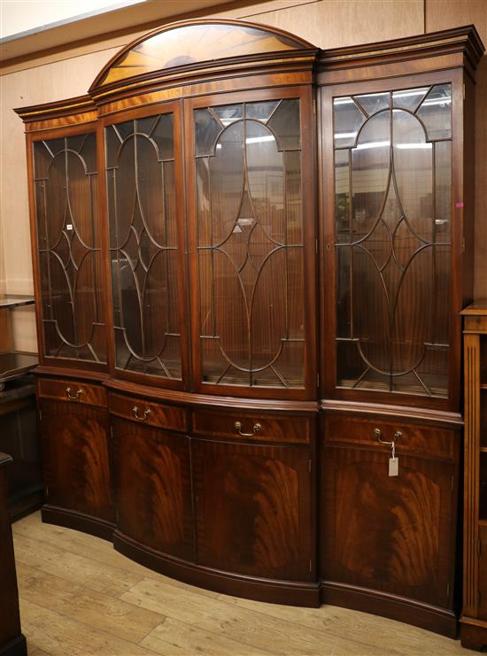 A Georgian style banded mahogany glazed bookcase with serpentine front